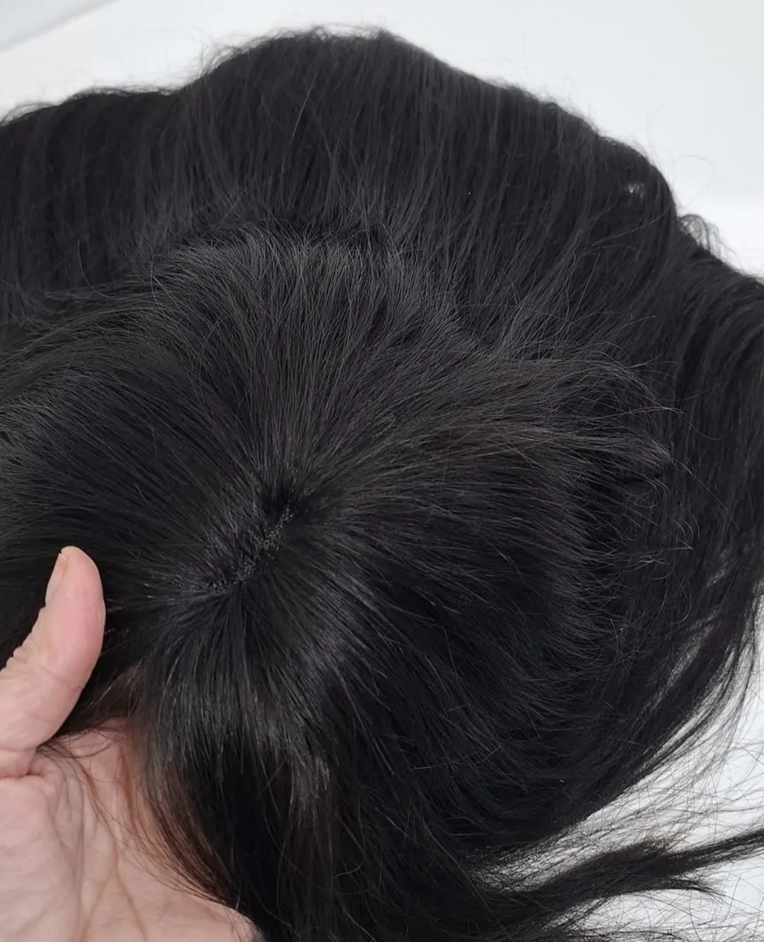 Detalj baze perike ručno vezane čvor po čvor od tamne prirodne kose